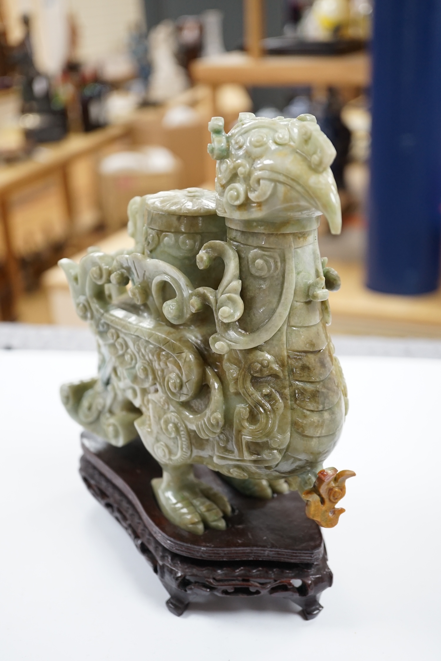 A large Chinese archaistic jadeite ‘phoenix’ vessel and cover, wood stand, 22cm high. Condition - fair